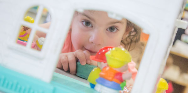 child playing with dollhouse